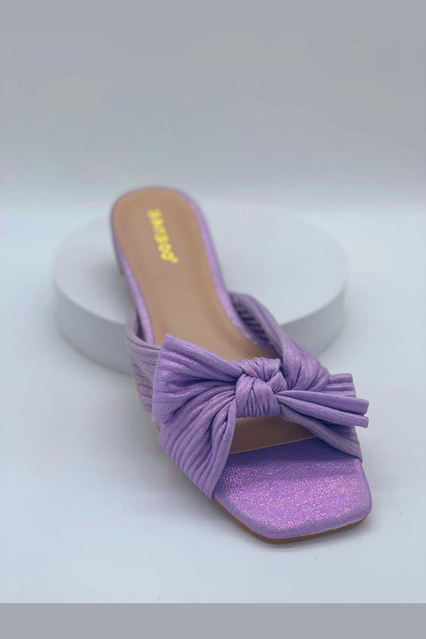 Sandalias planas a la moda con moño